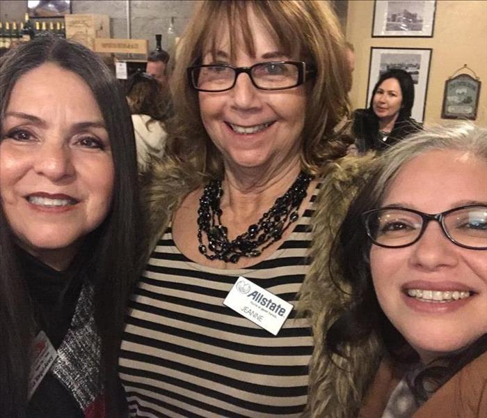 Three ladies standing together at a networking event 