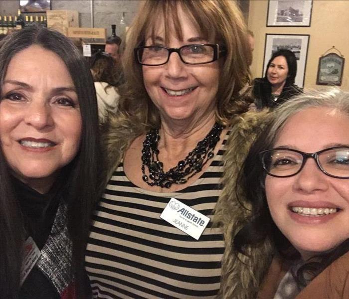 Three ladies standing together at a networking event 