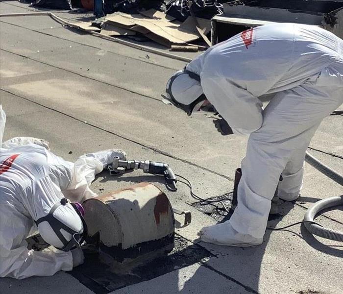 SERVPRO technicians in protective clothing on roof