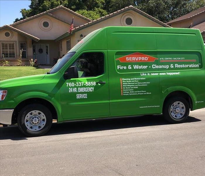 Small Green SERVPRO Vehicle Parked Curbside at a Client's Property