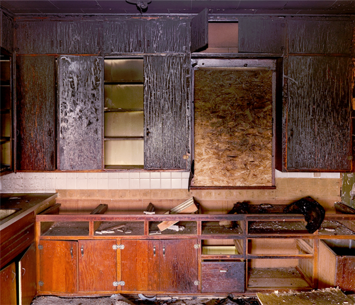 a fire damaged kitchen with soot covering the shelves