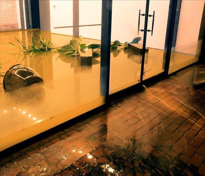 Agua que fluye a través de las puertas de una propiedad inundada.