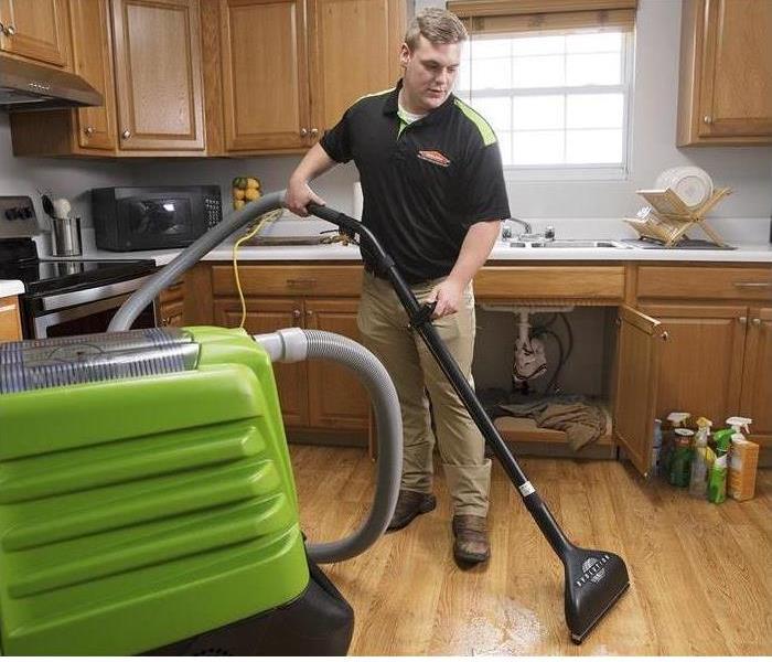 A man extracting water with a vacuum