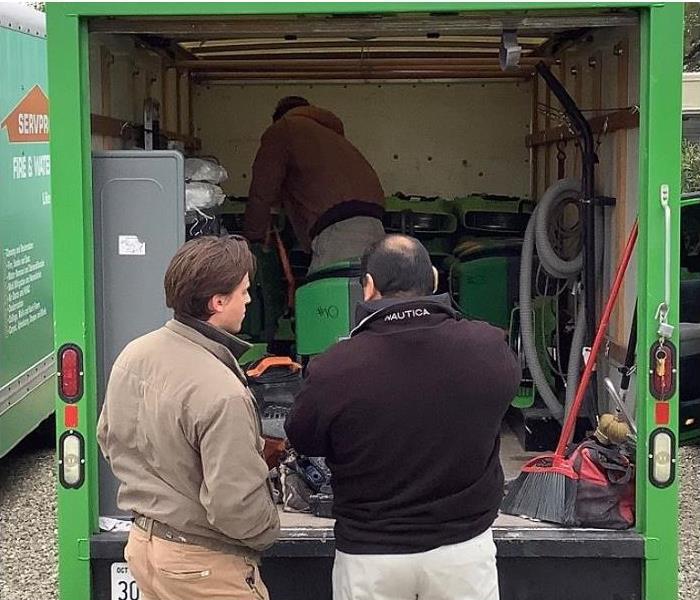 SERVPRO techs loading restoration equipment into SERVPRO vehicle